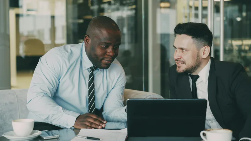 Two colleagues sitting together discussing paperwork