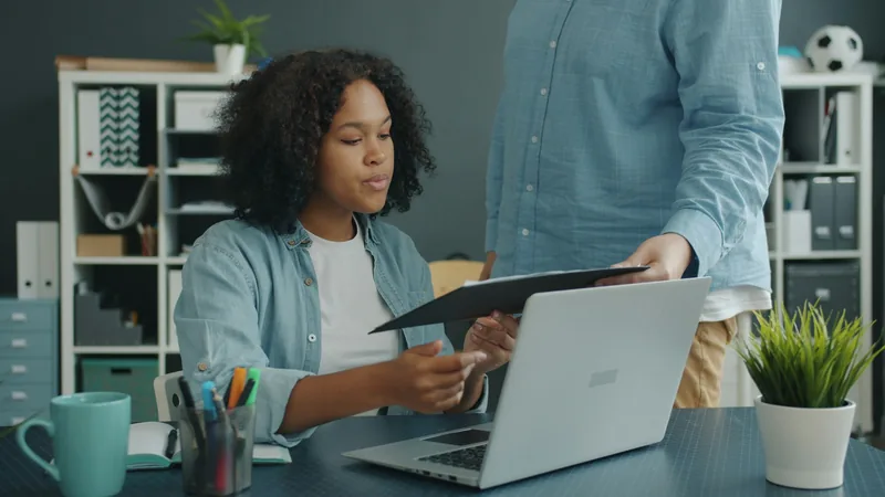 Two colleagues reviewing plan documents together at an office desk