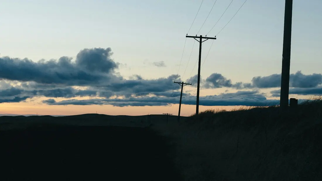 Sunset sky over power lines and fields
